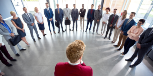 Leader in red jacket talking to his team in a circle
