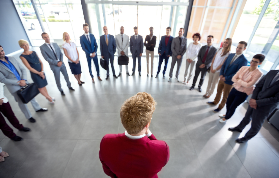 Leader in red jacket talking to his team in a circle